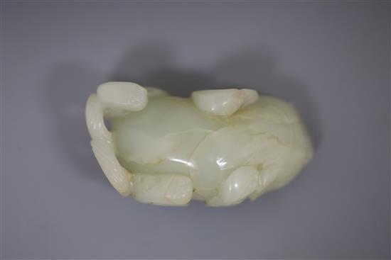 A Chinese pale celadon jade figure of lion-dog, bixi, 17th century, L. 6.8cm, wood stand